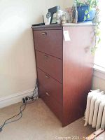 Side view of wood file cabinet with four drawers, showing height and finish.