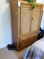 Full view of wooden chest dresser showing woven front panels and two lower drawers.