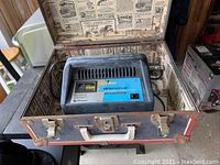 Full view of Ship n Shore 10 amp battery charger inside vintage metal case on table