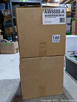 Two stacked brown cardboard boxes labeled AW8888-A, each indicating one pair of white Leviton in-wall speakers