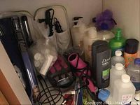 Photo of hair styling tools and multiple hygiene product bottles on shelf