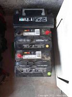 Top view of three stacked car batteries showing labels and terminals.