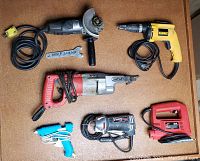 Photo showing the lot of six power tools on a table: Black & Decker angle grinder, Dewalt drill, Milwaukee Sawzall, Blue Electric glue gun, Bosch router spiral saw, and Power Max jig saw.