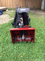 Front view of red Murray snowblower on grass
