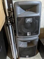 Two Peavey PR10 speakers stacked with tripod stands beside