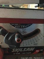 Close-up of the SKILSAW control panel with blade angle gauge and adjustment knobs, showing brand and amp rating.