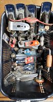 Top view of the lot showing multiple Stanley Bailey hand planes with wooden handles and knobs, some painted blue, all stored in a plastic basket, along with a vintage hand drill and various plane parts.