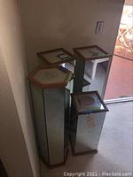 Four mirrored pedestals placed together, showing the three square and one hexagonal shape from above and side.