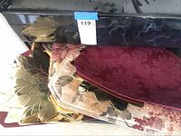 Image showing several fabric placemats with floral and damask patterns, including a burgundy damask placemat and others in pale florals.