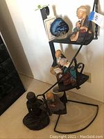 Full view of the stair style plant stand holding various items including small figurines and a geode stone, showing the overall condition and structure.