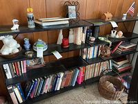 Wide view of multiple shelves filled with books and other decor items like vases, figurines and candles.
