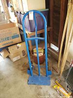 Full front view of blue heavy duty 2 wheel dolly showing arched handle and toe plate.