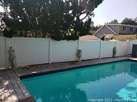 Set of 3 female statues placed by poolside along fence, showing scale and outdoor setting