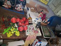 Wide view of the lot showing marionette dolls, string lights with red lanterns, green cactus and yellow bird decorations and boxes in background.
