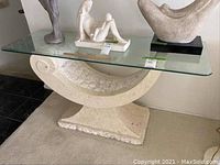 Full view of console table showing glass top and faux marble curved base.
