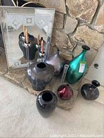 Overview of all vases, reflective wall mirror, and metal candlestick with three candles