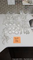 Wide view of various crystal chandelier parts laid out on a counter with a 'lot 52' orange paper label.