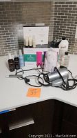 Full display of hair care lot including products, hot rollers, hair dryer, curling iron, and twist towel