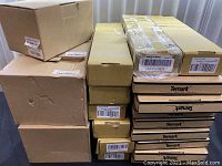 Boxes stacked for lot display, mostly labeled Temark and other labels, showing signs of dents and wear.