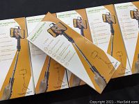 Set of five boxed smart shooting phone holders with telescopic selfie sticks, packaging shows wear with dents and scratches.