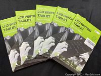 Five unopened boxes of LCD writing tablets model H8A, showing front packaging with green and black design.