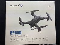 Box showing SP500 foldable drone by SNAPTAIN with GPS and age 14+. Box shows product image and features.