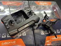 Two Gokyu mini drones in packaging with one controller showing dual joystick layout with buttons and foldable clear flap.