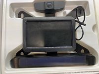 View of monitor and wireless camera with solar panels in original molded plastic packaging tray.
