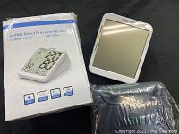 Photo of HOMIEE BP1003 blood pressure monitor with original packaging and cuff, showing product and condition