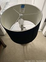 Top interior view of the black fabric drum lampshade with metal frame and bulb holder.