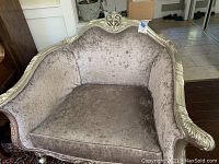 Front view showing the velvet seat and backrest with ornate silver frame.
