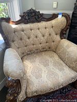 Front and right perspective showing carved wood frame and upholstery