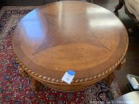 Top view of round wood coffee table showing wood grain pattern and carved edges.