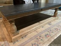 Photo showing the wooden base with turned legs and bottom shelf, highlighting the natural wood finish and craftsmanship.