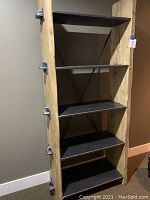 Front view of five-tier industrial bookshelf, showing wood shelves and metal frame