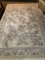Full view of the rectangular floral pattern area rug on floor.