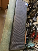 Rectangular LED display panel, black pixel grid front, metal frame, visible signs of wear, placed on table.