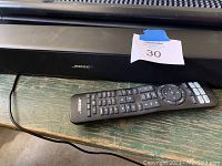 Front view of Bose Solo 5 soundbar and remote on wood surface