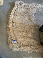 Full view of hammock chair laid flat showing woven net design and wooden spreader bar with hanging loops.