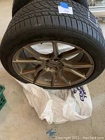 Top angled view of the used tire with the Niche multi-spoke alloy rim in bronze.