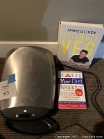 George Foreman grill with two cookbooks 'Ultimate Veg' by Jamie Oliver and 'Dr. Atkins' New Diet Revolution' by Robert C. Atkins, M.D.