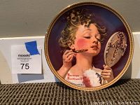 Collector plate featuring Norman Rockwell artwork of girl applying lipstick, with seller's lot number visible