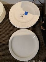 Seven plates on a carpeted floor with label 'monarch 84' visible on top plate stack.