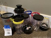 Magic Bullet blender base with multiple blending cups with different colored lids and blade attachments