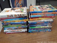 Photo of stacked DVDs showing titles including Toy Story 2, Toy Story 3, Finding Dory, Mulan, Lego Batman, Storks, Despicable Me 3, Dumbo, Turbo.