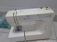 Full side view of beige Kenmore 8 sewing machine showing control panel and needle area.
