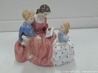 Front view of Royal Doulton porcelain figurine 'The Bedtime Story' showing a woman reading a book to two children.