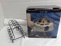 Full view of boxed cake plate set showing the footed plate with clear dome cover and decorative cake with flowers printed on the box.