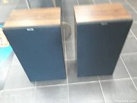 Two Philips speakers side by side displaying wood grain tops and black front fabric with Philips logo.