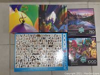 Lot of five jigsaw puzzles showing colorful balloon images, dog breeds puzzle, a lake image puzzle, and floral scene puzzle.